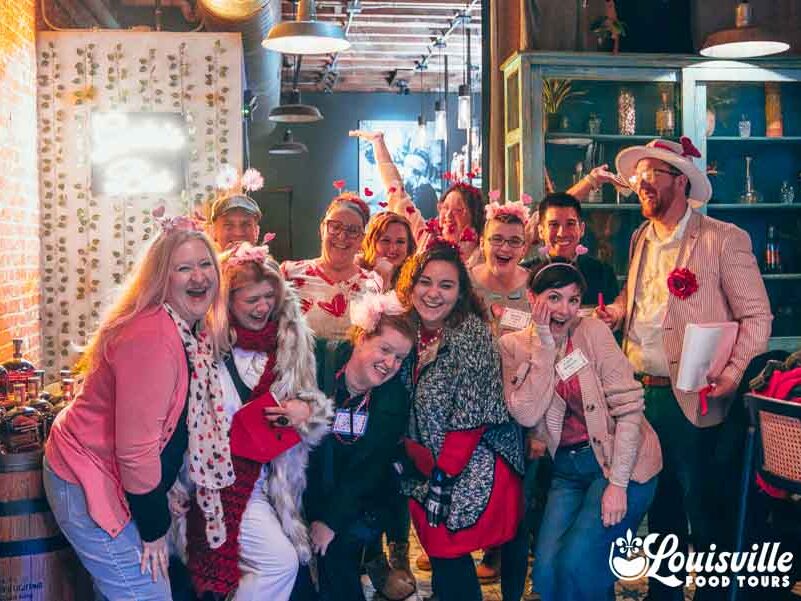 Group in Valentines Day themed clothing on a Murder Mystery Food Tour in Louisville Kentucky with Louisville Food Tours